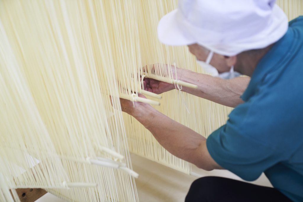麺を伸ばす職人
